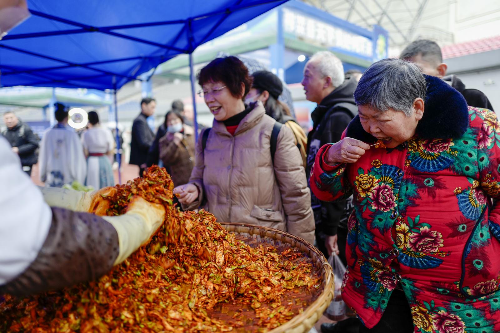 2月20日，在第五届中国重庆·涪陵榨菜产业国际博览会现场，观众在品尝手工涪陵榨菜产品。刘潺 摄.JPG