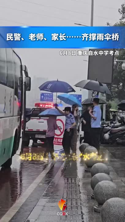 6月8日上午 重庆字水考点突然降下大雨，执勤民警为考生架起伞桥