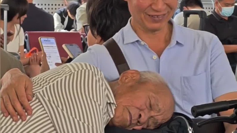 父亲安心地依偎在儿子怀里，老人暖心的一笑，“融化”了众多网友