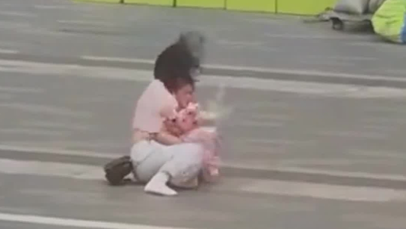 台风“红霞”登陆前夕 母女在狂风中寸步难行 附近安保小哥挺身而出
