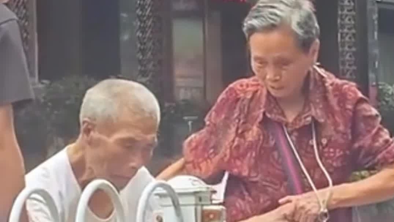 老人坐轮椅过马路有些困难，前后两辆车的司机见状下车帮忙
