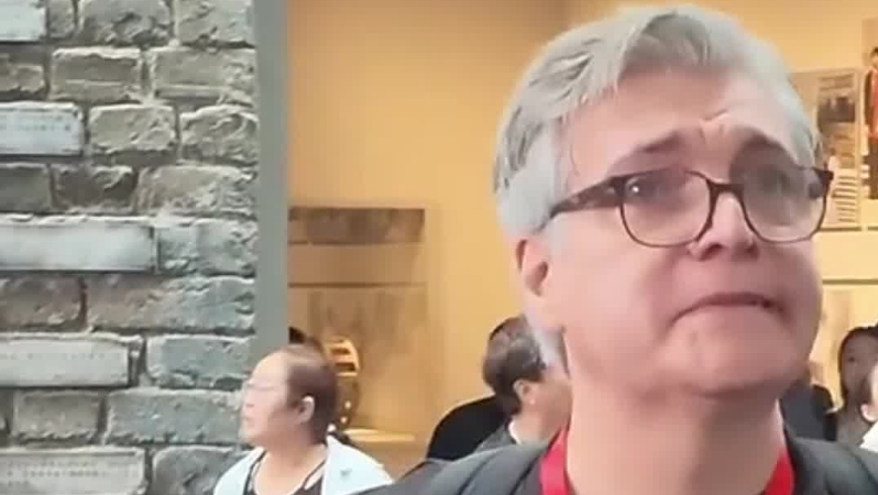 在侵华日军南京大屠杀遇难同胞纪念馆结束语墙前，一名外国记者驻足良久，潸然泪下